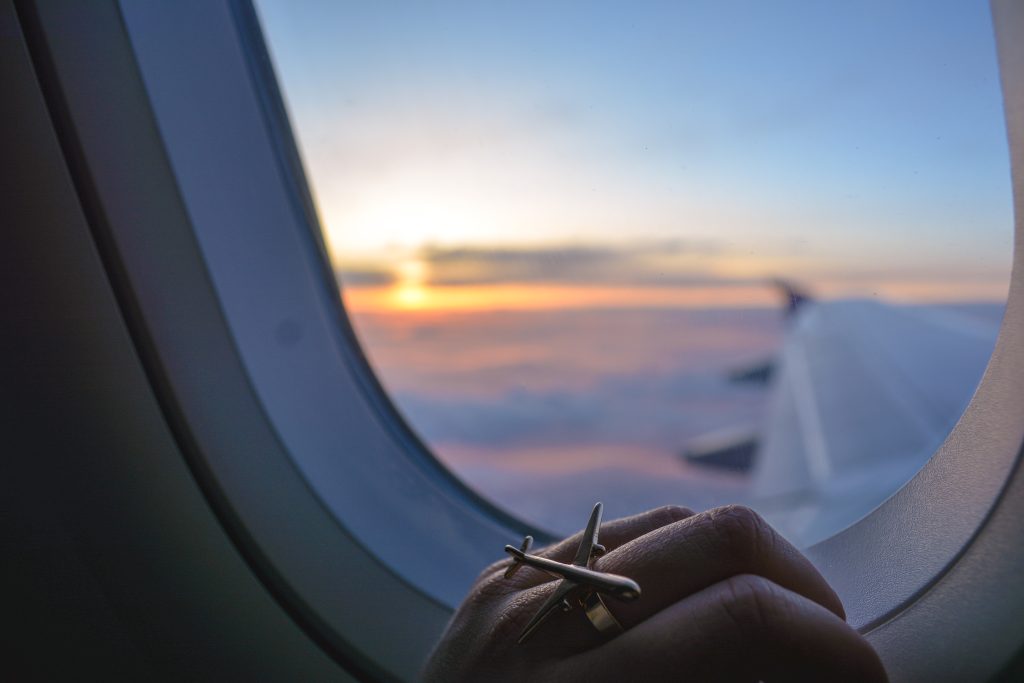 cropped-image-hand-window-airplane